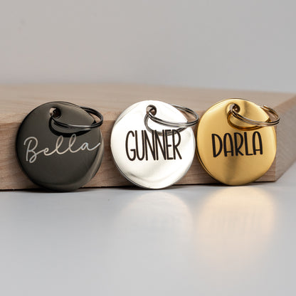 Three round metal tags labeled 'Bella', 'Gunner', and 'Darla' on a wooden block.